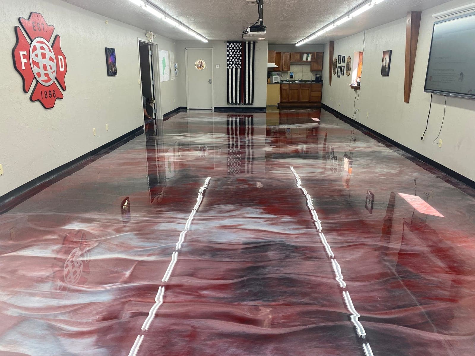 Fire station apparatus bay finished in a red and white metallic resin floor