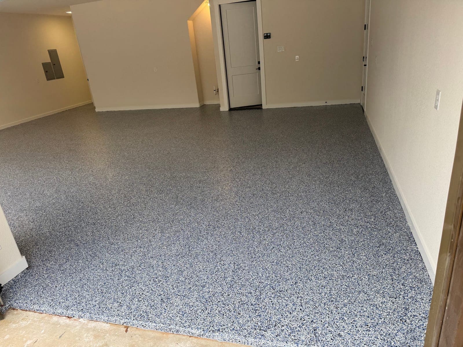 Finished interior room with a full-broadcast decorative flake floor