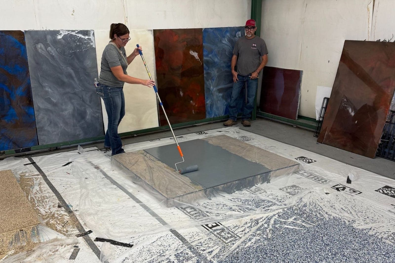 Academy participant rolling a coating onto a sample panel in the training bay
