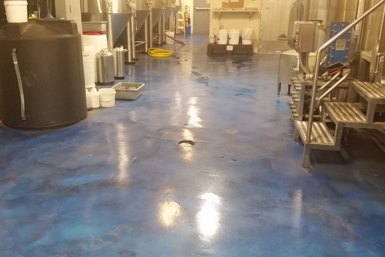 Industrial space finished in a blue metallic resin floor